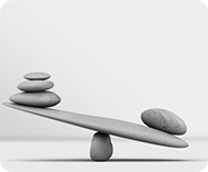 Stones balanced on a seesaw representing budget balance