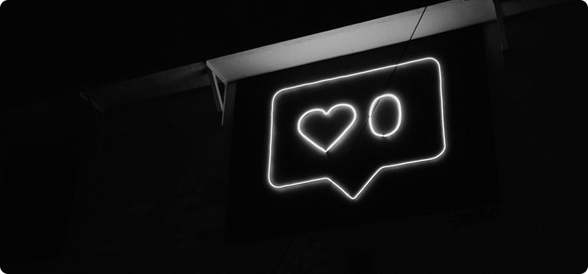 Neon sign showing a heart and like notification