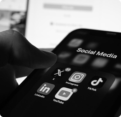 Hand holding a phone showing social media app icons