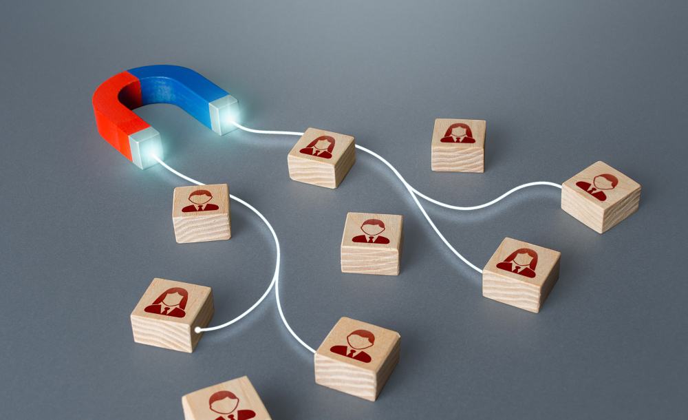 Magnet attracting wooden blocks with customer icons, illustrating lead generation