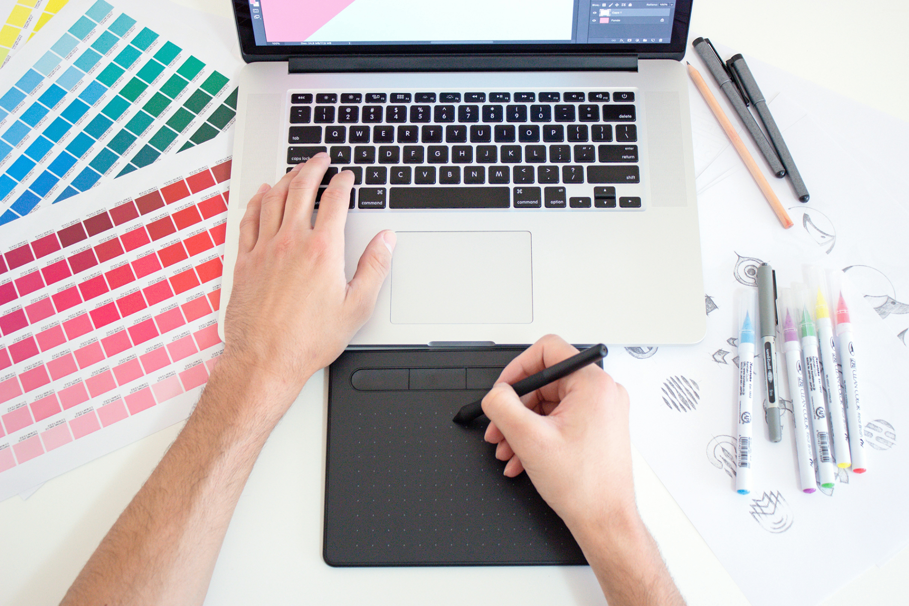 Designer working on laptop with color swatches