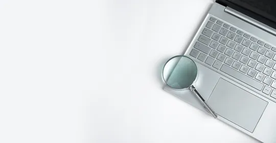 Local SEO services - laptop keyboard with magnifying glass